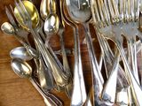 beaucoup de cuillères en argent et de cuillères à soupe sur une table