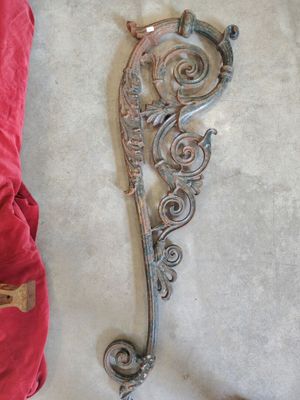 a metal hook on the wall next to a red pillow