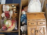 two boxes with dolls in them sitting on the floor