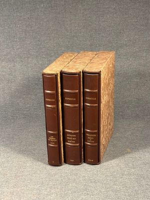 three books are stacked on top of each other on a gray surface