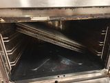 une porte de four ouverte avec plusieurs plaques à l'intérieur