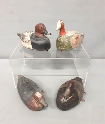 trois canards en bois posés sur une étagère transparente, posée elle-même sur une surface blanche