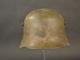 an old helmet on a metal stand against a gray background