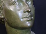 a bronze bust of a woman with short hair