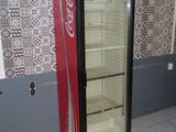 a coca cola cooler sitting in the corner of a room