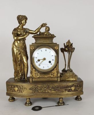 une horloge en or surmontée d'une statue