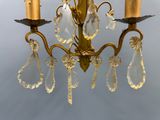 a gold colored chandelier with crystal drops hanging from it