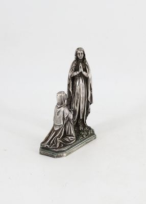 une statue en argent représentant une femme agenouillée à côté d'un enfant