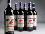 six bottles of red wine are lined up in a row
