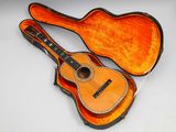 guitar in a case on a white surface with a white background