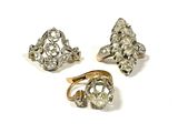 trois types de bagues différents et une bague posée sur une surface blanche