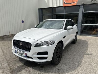 a white jaguar suv parked in front of a building