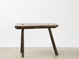 a small wooden bench sitting on top of a cement floor