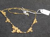 gros plan d'un collier en or sur une surface noire