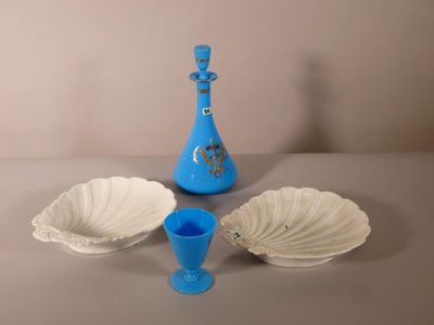 un vase bleu et trois assiettes blanches posés sur une table