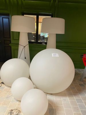 a lot of white balls on the floor next to a lamp