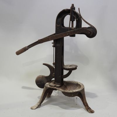 pressoir à vin ancien en fonte avec une poignée en bois, sur fond blanc