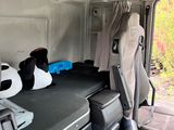 an image of the inside of a van with a bed and luggage