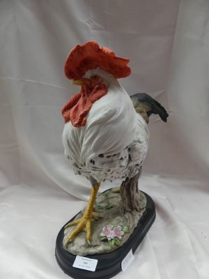 une figurine représentant un coq coiffé d'un chapeau rouge
