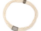 a close up of a necklace with pearls and a silver clasp