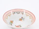 a white bowl with a red rim and a yellow handle