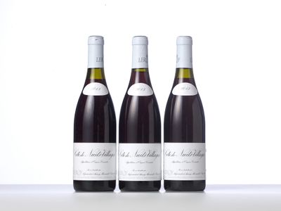 three bottles of wine are lined up on a white surface