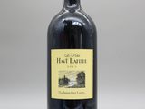 une bouteille de vin rouge posée sur une table blanche