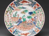 a colorful plate with a bird on it on a table