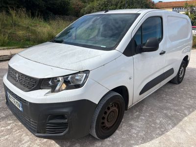 une camionnette blanche garée sur un parking à côté d'un champ