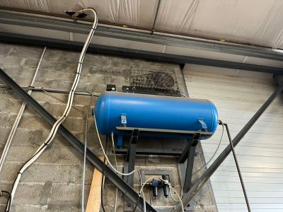 un réservoir bleu posé sur une table dans un garage