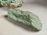 a rock with a green leaf on it next to some rocks