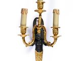 a wall sconce that has three candles on it