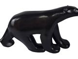 une figurine d'ours noir sur fond blanc