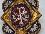 une image représentant une broche bleue et dorée ornée d'une croix