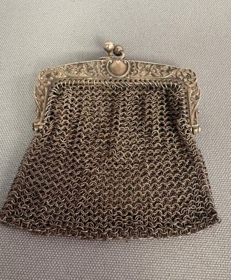 a silver metal purse with a chain around it