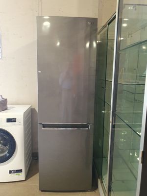 un réfrigérateur argenté et une machine à laver dans une pièce