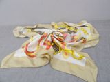 yellow and white scarf with a design on it laying on a gray surface
