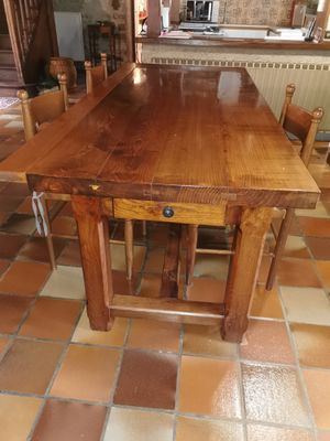 a wooden table and chairs in a room with tile flooring