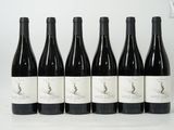 six bouteilles de vin sont alignées sur une surface blanche