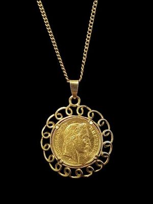 un pendentif en forme de pièce d'or ornée d'une couronne, monté sur une chaîne