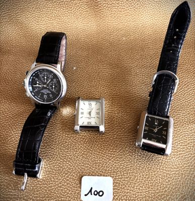 two watches sitting next to each other on a brown surface