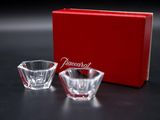 a close up of two small glass bowls in front of a red box