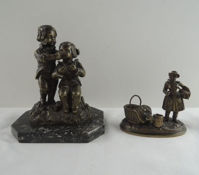 trois figurines d'enfants en bronze et un panier posés sur un socle en marbre