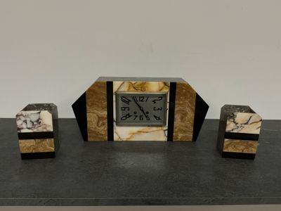 une horloge posée sur une table, à côté de deux blocs