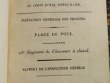 un vieux livre posé sur une table, à côté d'une nappe