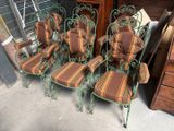 six green wrought chairs with striped cushions in a garage