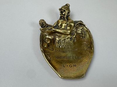 a gold plate with a figurine of a woman sitting on top of a heart