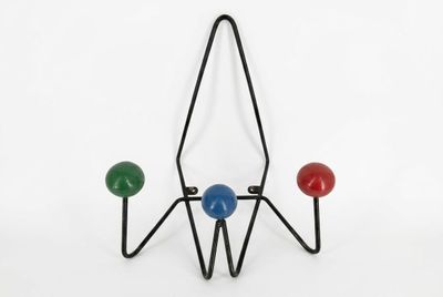 a close up of a metal rack with three balls on it
