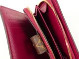 someone is holding a red purse with gold zippers on it