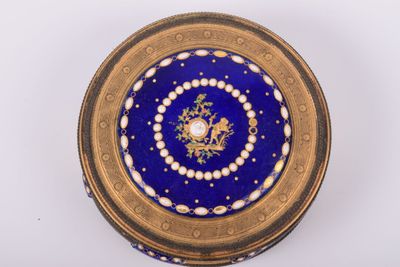 une image représentant une boîte bleue et dorée posée sur une surface blanche